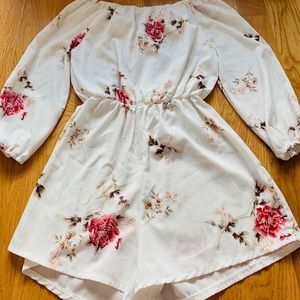 This is a white floral print romper.